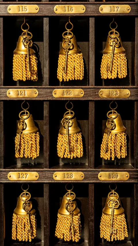 Brass Paradores room keys with tassels on wooden hotel rack