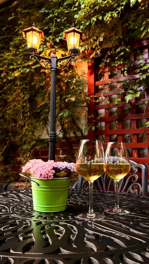 Two glasses of Spanish cava on a patio table in a quiet Parador courtyard