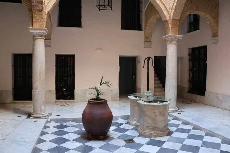 Marble-columned Andalusian patio courtyard with stone fountain in a Parador