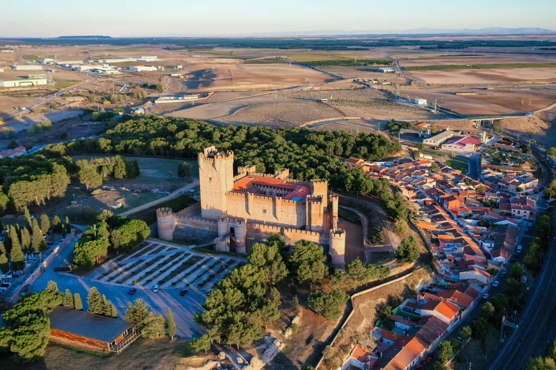 Aerial view of Parador de Alarcon medieval castle surrounded by forest and village
