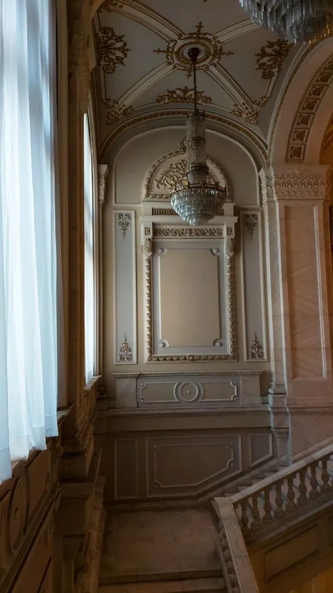 Luxurious interior design featuring a grand staircase, ornate ceiling, and a stunning chandelier.