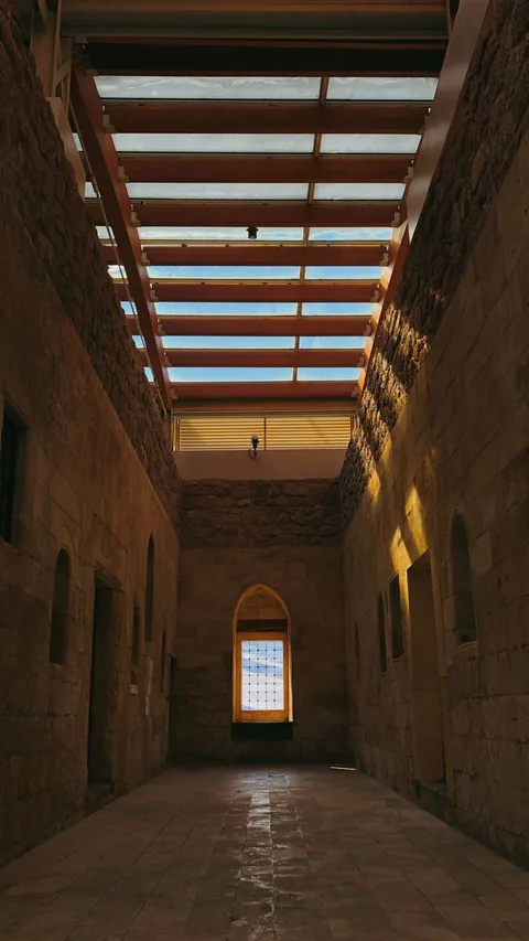 Glass-roofed corridor in ancient sandstone gallery contrasting historic and modern wings