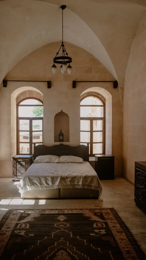 Historic castle bedroom with stone vaulted ceiling and double bed