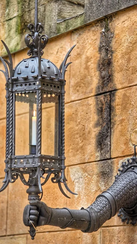 Wrought-iron medieval torch wall sconce on rough stone wall of castle room