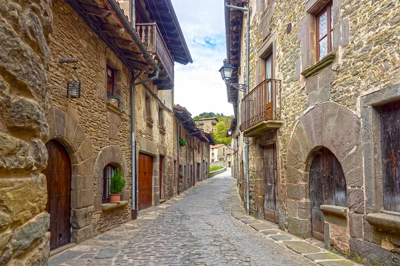 Narrow medieval cobbled street in a historic Spanish village on a Paradores route