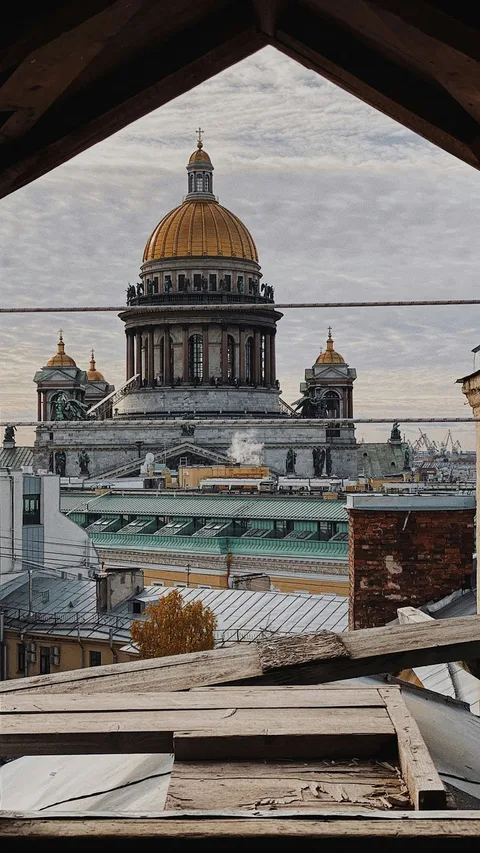 Captivating view of St. Isaac's Cathedral from a rustic attic in Saint Petersburg, Russia.
