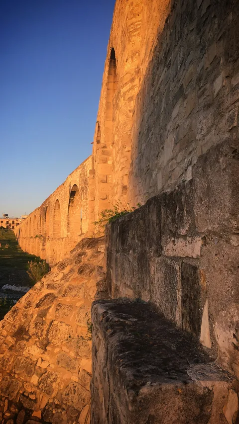 Sunlit stone walls of Puente Nuevo near Parador de Ronda at sunset