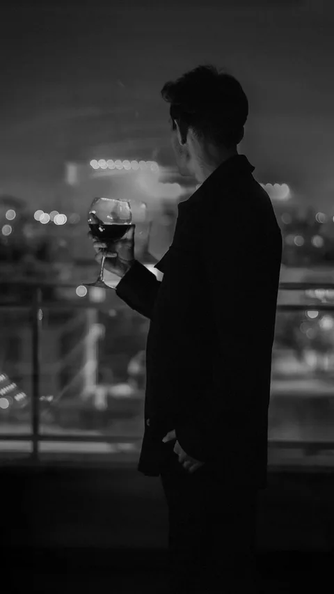 Wine glass on Parador de Toledo balcony overlooking old town night lights
