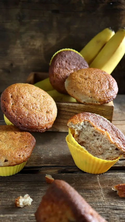Delicious homemade banana muffins displayed on a rustic wooden table, highlighting freshly baked goodness.