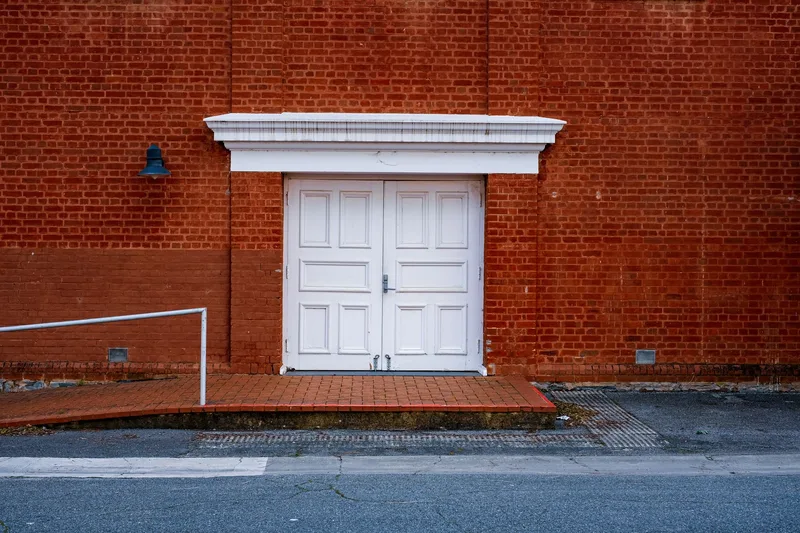 Historic brick Parador entrance with white doors and accessible ramp
